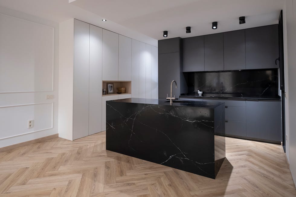 Cocina abierta con isla central diseñada en mármol negro