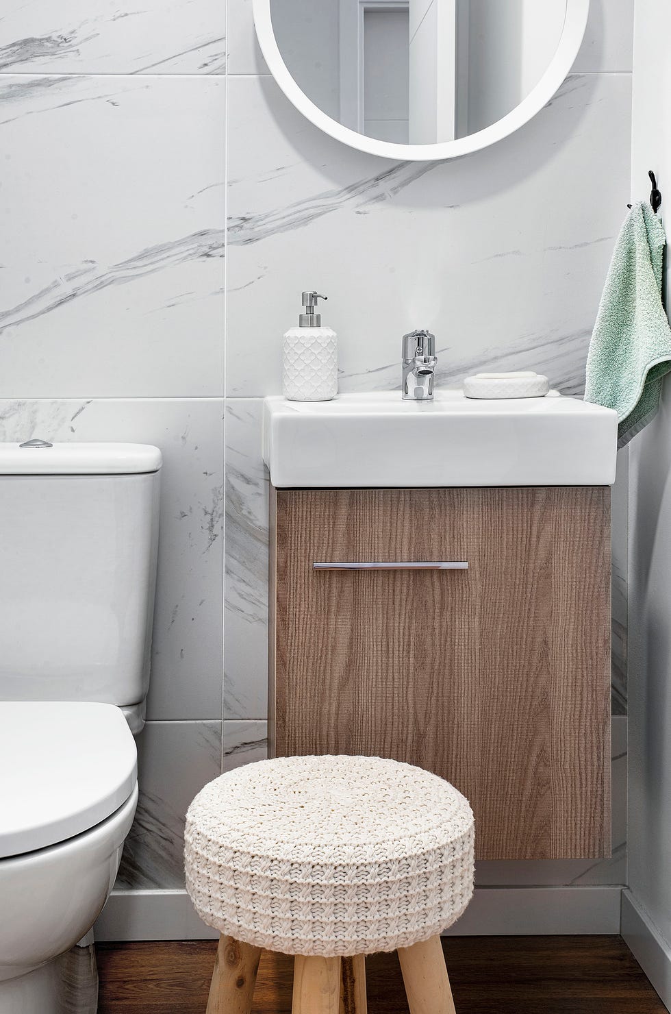 aseo con mueble de lavabo suspendido y pared revestida con efecto mármol