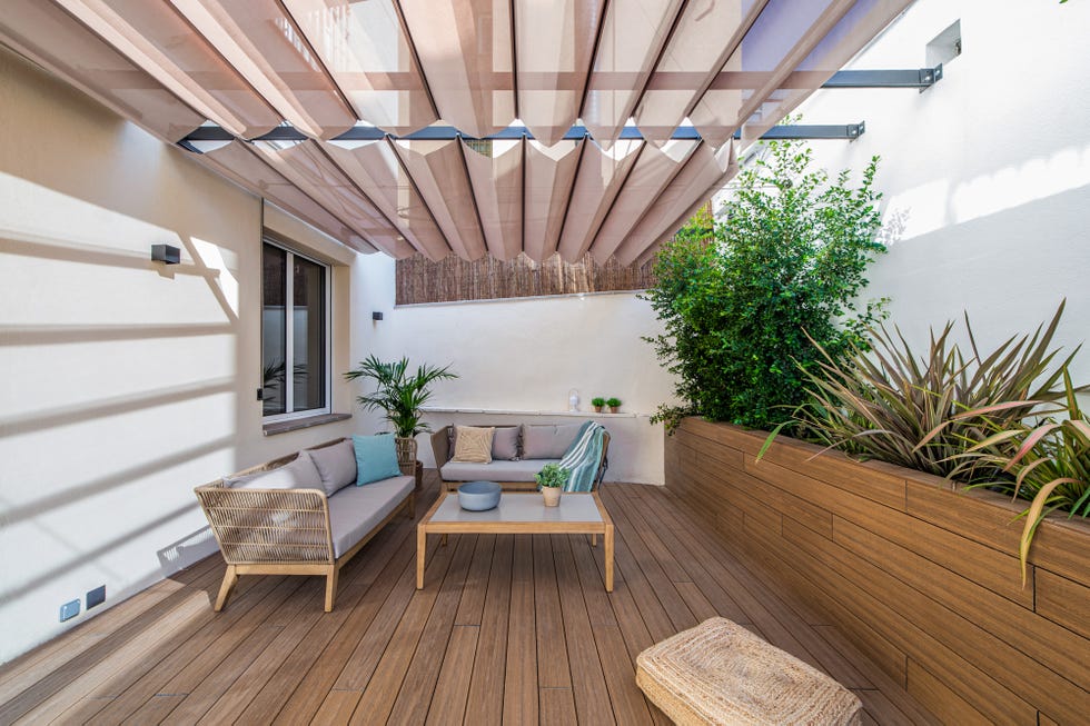 terraza con toldo, entarimado de madera y dos sofás