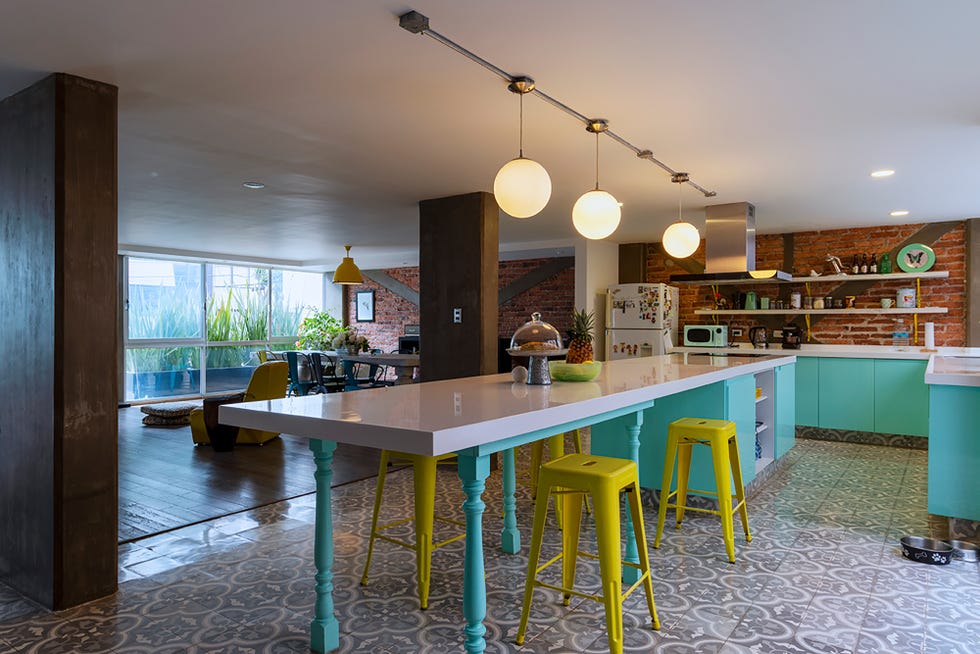 cocina abierta con isla central y barra de desayunos decorada con detalles azul turquesa