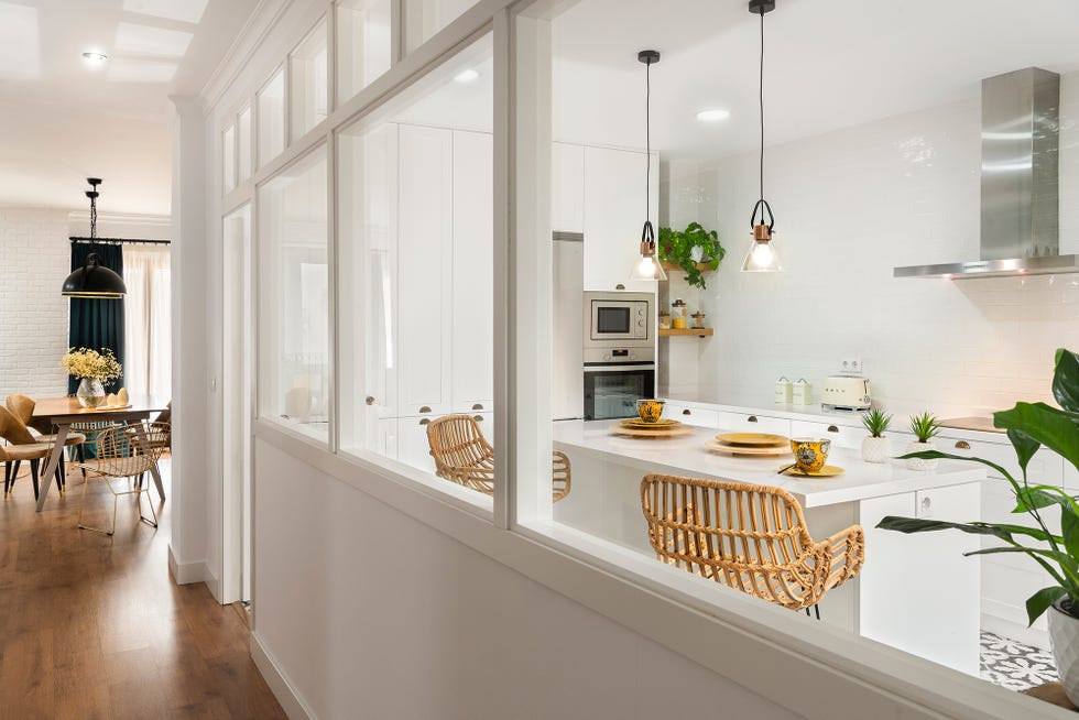 cocina blanca de diseño moderno con isla central y cristalera