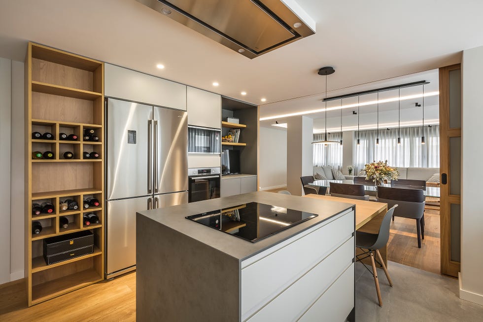 cocina abierta de diseño moderno con isla central efecto cemento y bodega