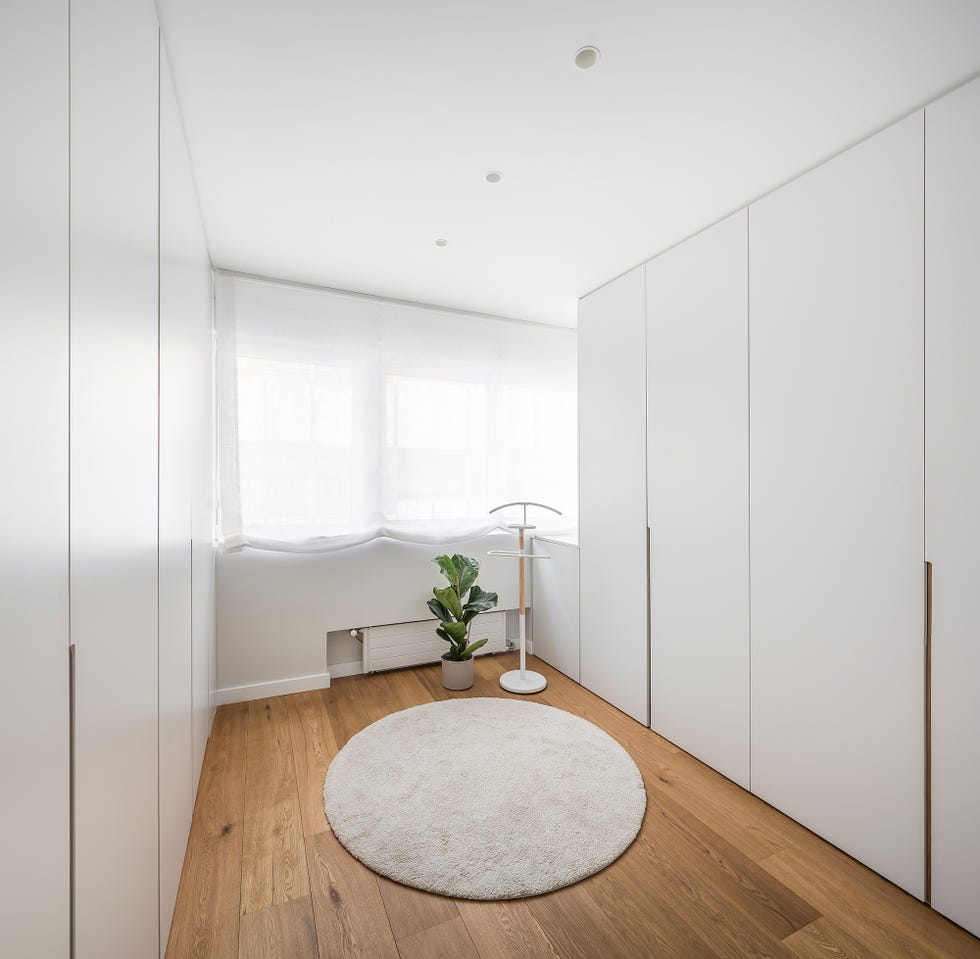 vestidor con armarios sin tiradores en color blanco y suelo de madera