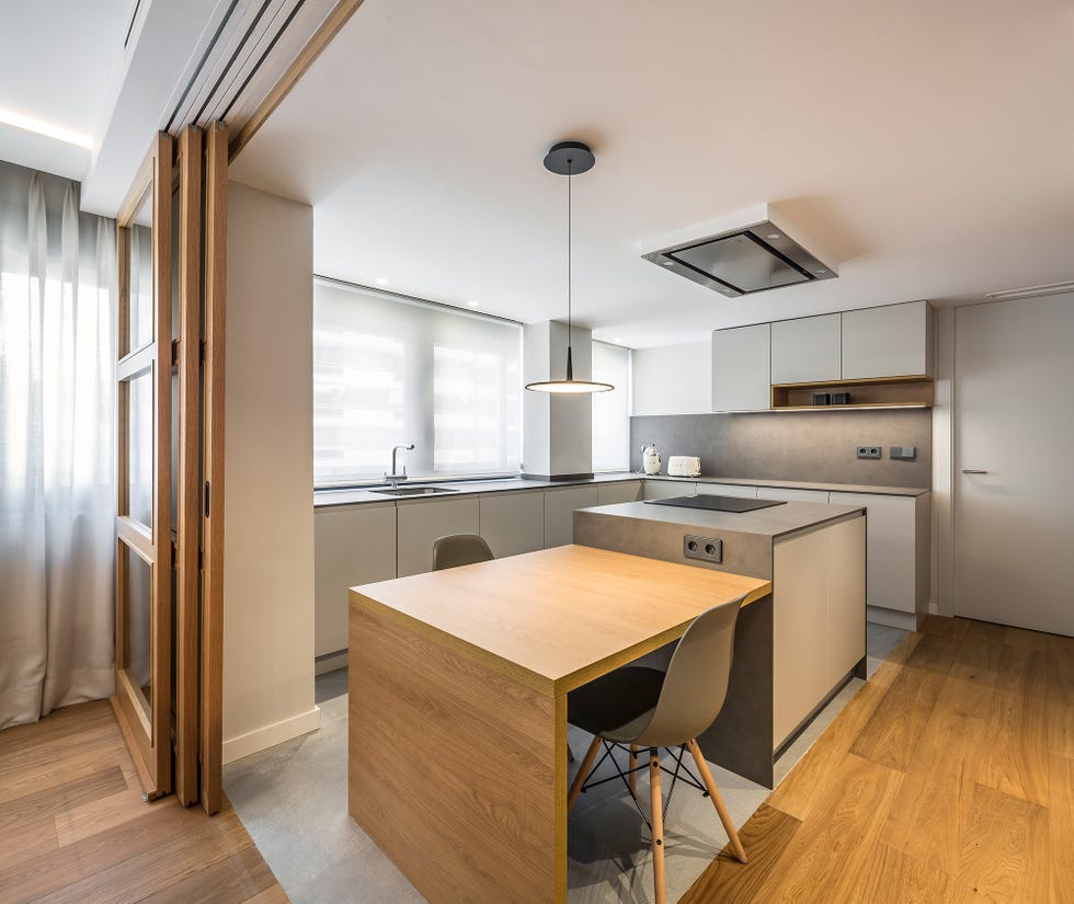 cocina abierta de diseño moderno con isla central anexa a un office de madera
