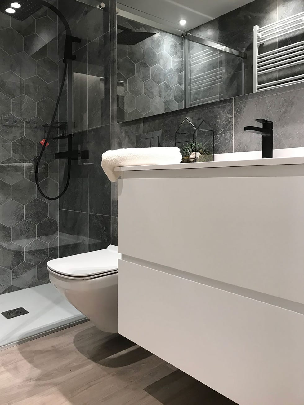 baño con ducha de obra y mueble flotante de lavamanos en blanco