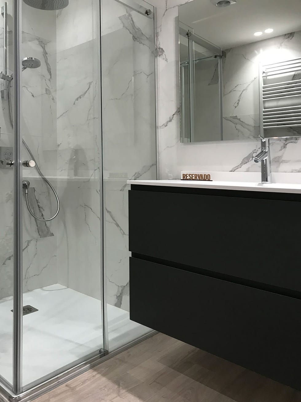 baño con ducha de obra y mueble flotante de lavamanos en negro