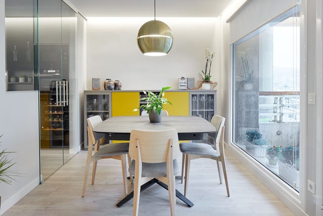 comedor de diseño moderno con mesa y sillas de madera y lámpara de techo dorada
