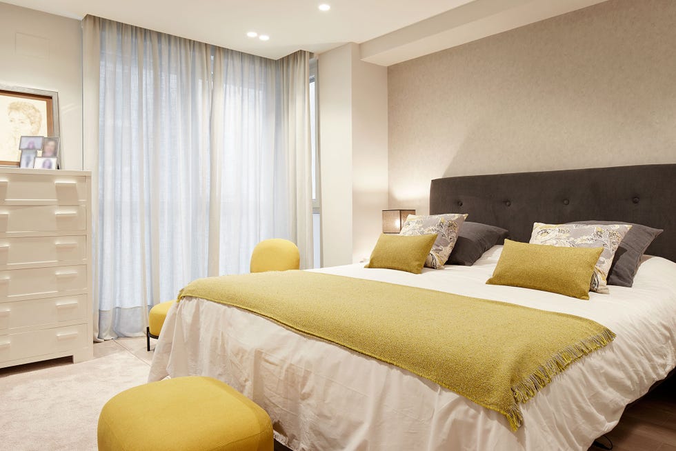 dormitorio moderno decorado en tonos neutros con detalles mostaza