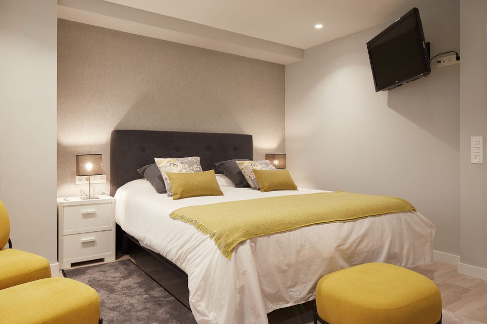 dormitorio moderno decorado en tonos neutros con detalles mostaza
