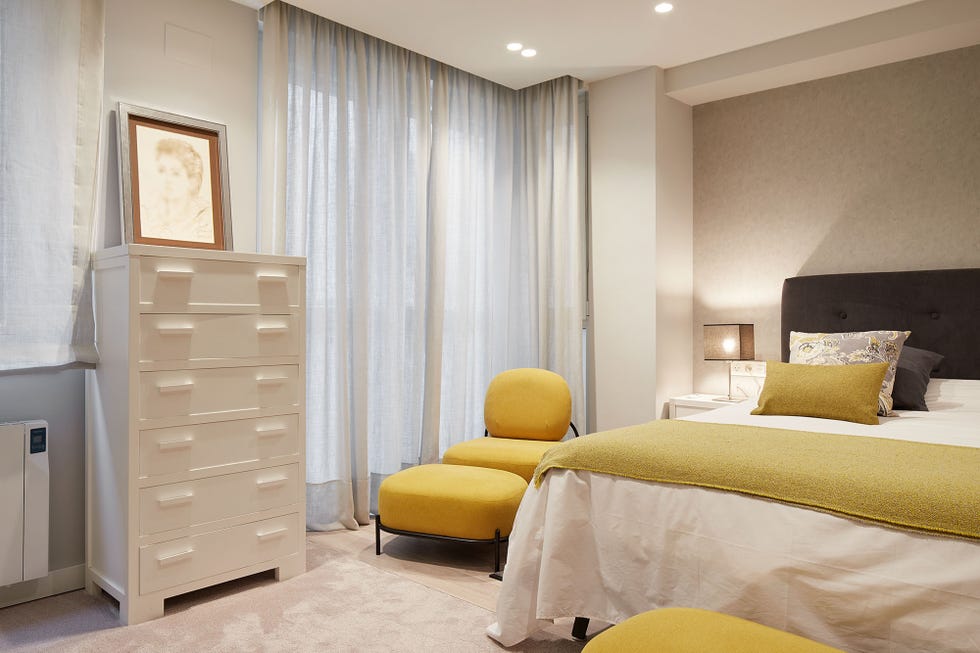 dormitorio moderno decorado en tonos neutros con detalles mostaza