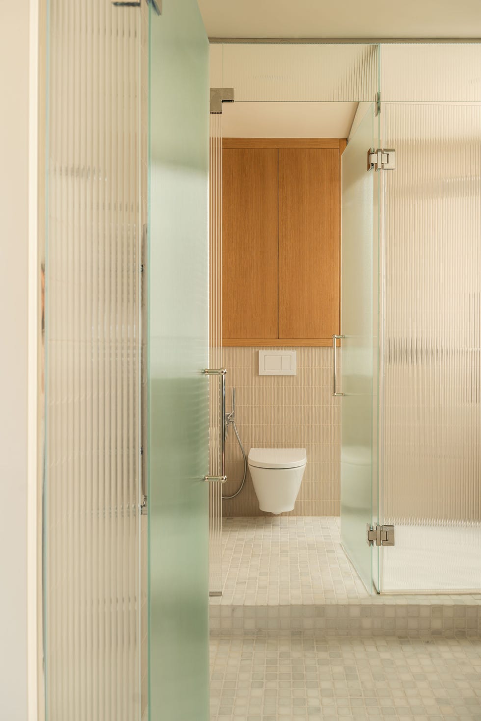 baño con azulejos beige y sanitario flotante