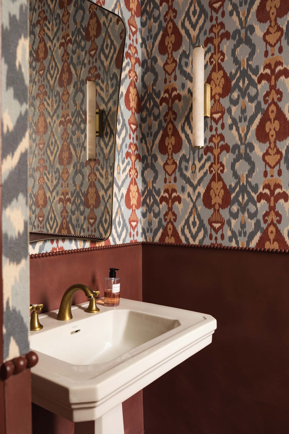 baño con pared en color burdeos y papel papel pintado con motivos victorianos