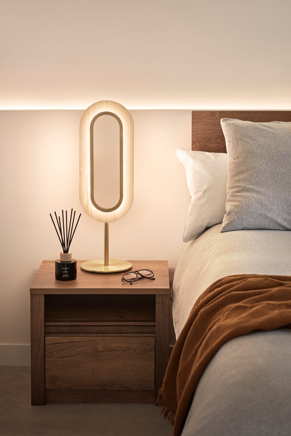 mesita de noche de madera con lámpara de diseño contemporáneo