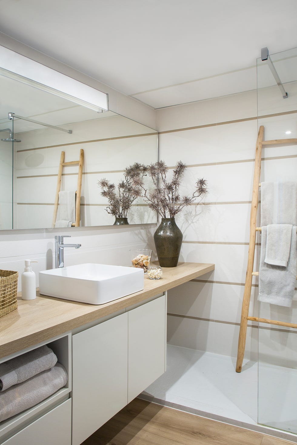 Baño decorado en tonos piedra y blancos con madera
