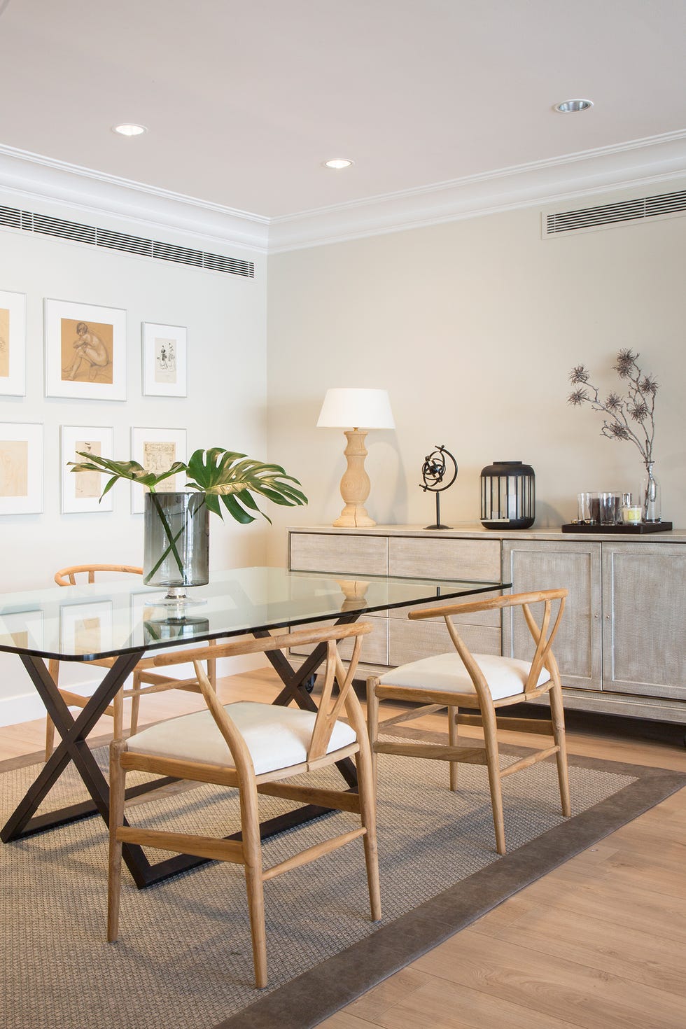 Mesa de comedor con tapa de cristal y cuatro sillas de madera