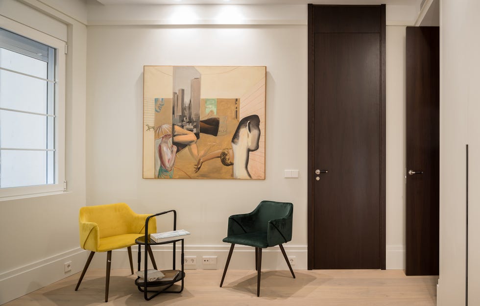 rincón de lectura con dos butacas de diseño contemporáneo de terciopelo en verde y amarillo