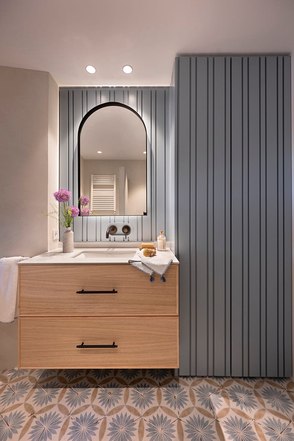 baño con mueble de madera y pareces revestidas en azul