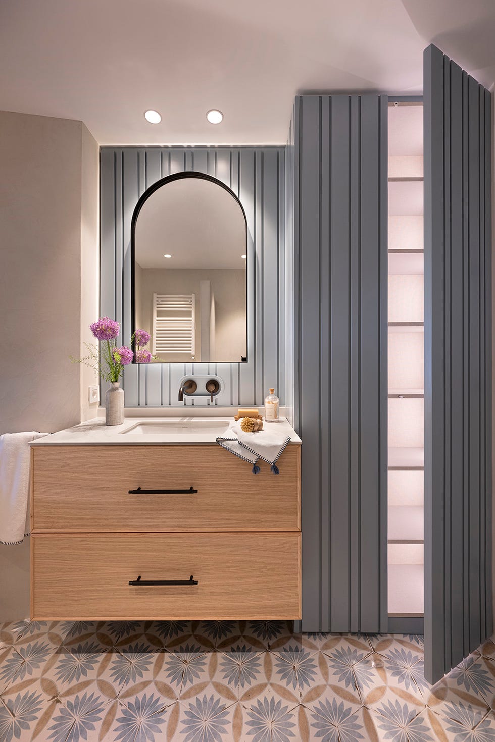 baño con mueble de madera y pareces revestidas en azul