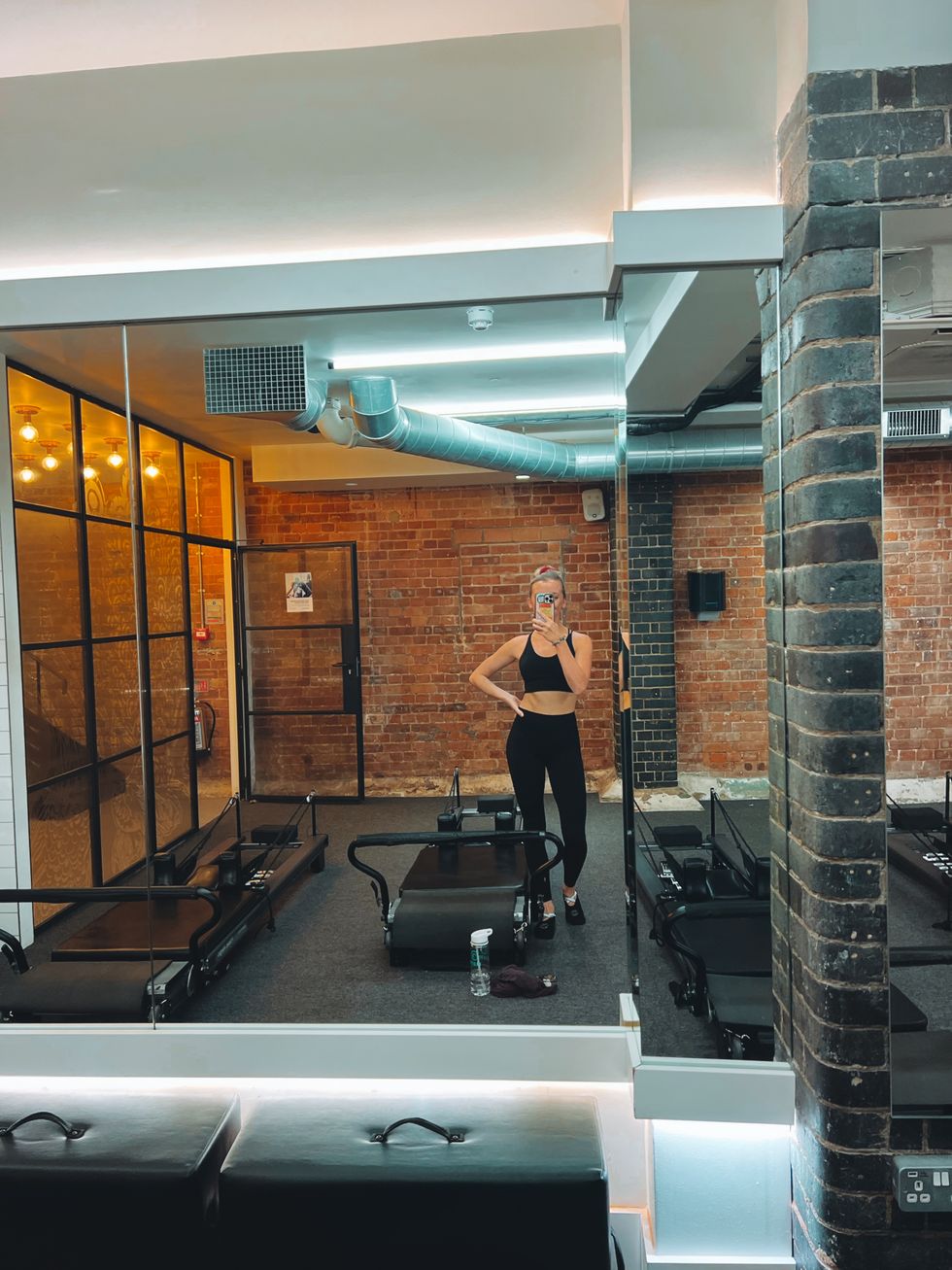 woman taking selfie by reformer pilates machine