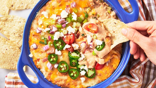 refried bean dip topped with cheese, red onion, jalapenos, and tomatoes served with tortilla chips