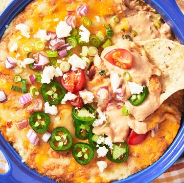 refried bean dip topped with cheese, red onion, jalapenos, and tomatoes served with tortilla chips