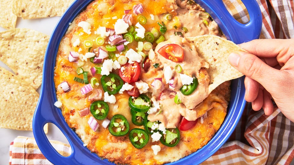 refried bean dip topped with cheese, red onion, jalapenos, and tomatoes served with tortilla chips