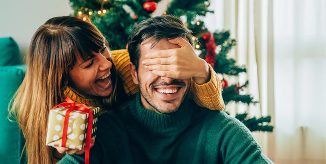 Romantic young couple exchanging Christmas gifts