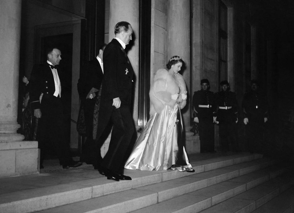 princess elizabeth of england, wearing an evening gown and a tiara, accompanied by her husband philip, duke of edinburgh hidden, leaves the elysee palace on may 14, 1948, accompanied by mr dumaine, chief of the protocol, after the dinner offered in their honor by the president of the republic vincent auriol, on the first day of their official visit in france   three years after the end of the second world war, the twenty two year old princess, accompanied by her husband and pregnant with the future prince charles, made a four day official visit to paris, her first trip outside the commonwealth photo by    afp photo by  afp via getty images
