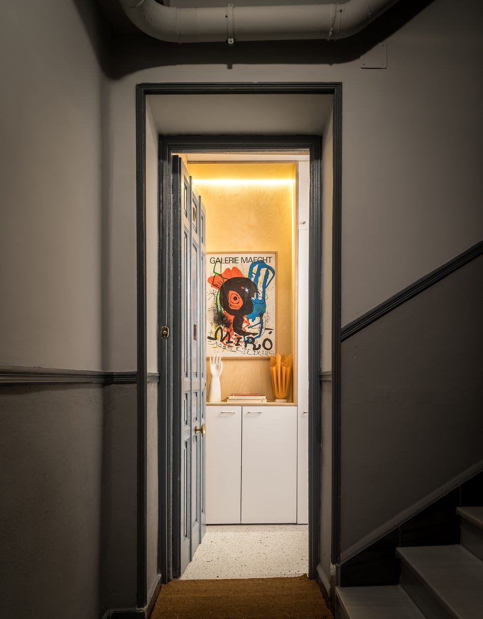 vista de la entrada y el recibidor con un póster de miró
