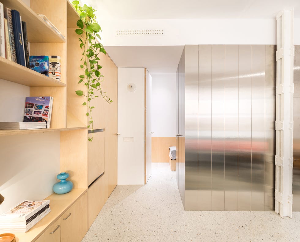 estantería de abedul y volumen de acero inoxidable en el salón