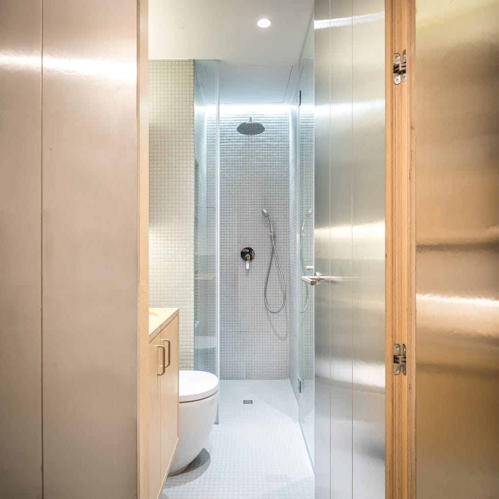 baño con ducha de obra y muebles de madera de abedul