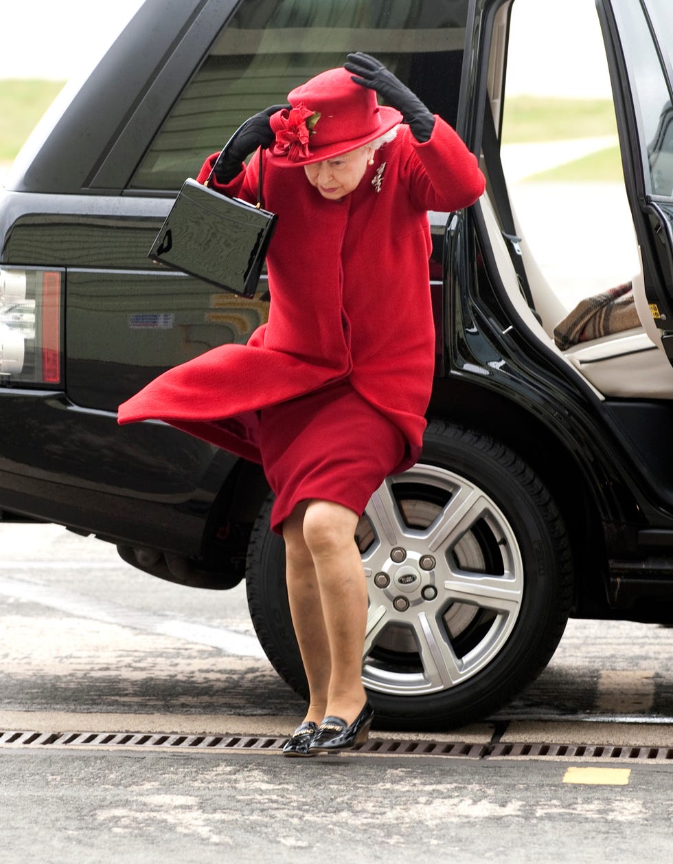 la reina isabel ii en una divertida foto luchando contra el aire