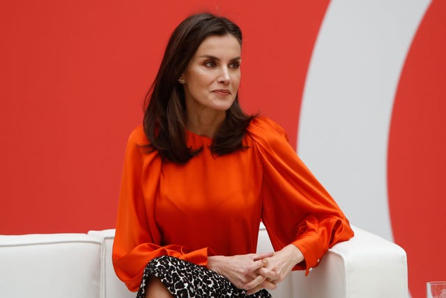 Reina Letizia con blusa naranja y falda tubo animal print