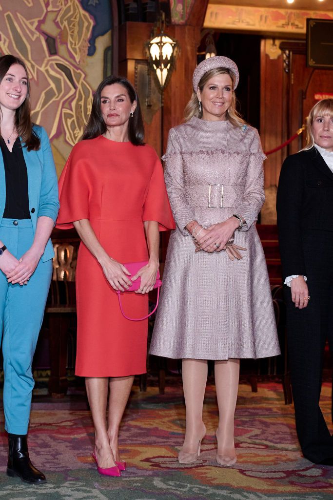 la reina letizia con abrigo rosa y vestido naranja