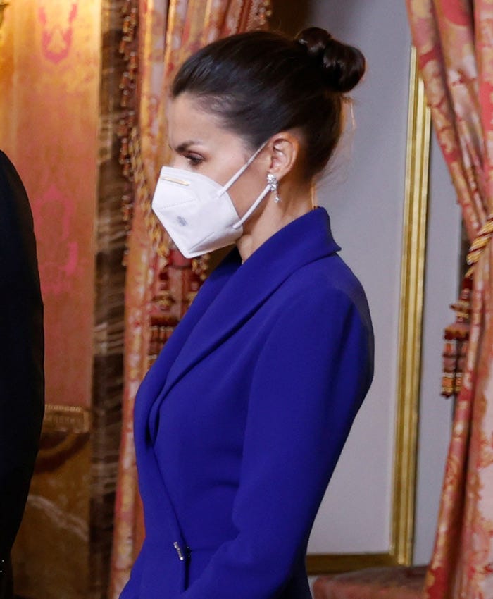 la reina letizia con la cabeza agachada y gesto serio en un acto oficial