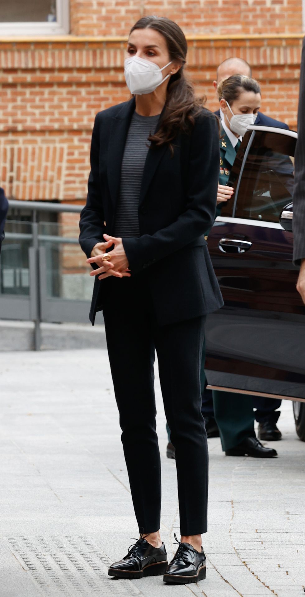la reina letizia look con traje con americana entallada y pantalones de vestir pitillos negros y zapatos con plataforma