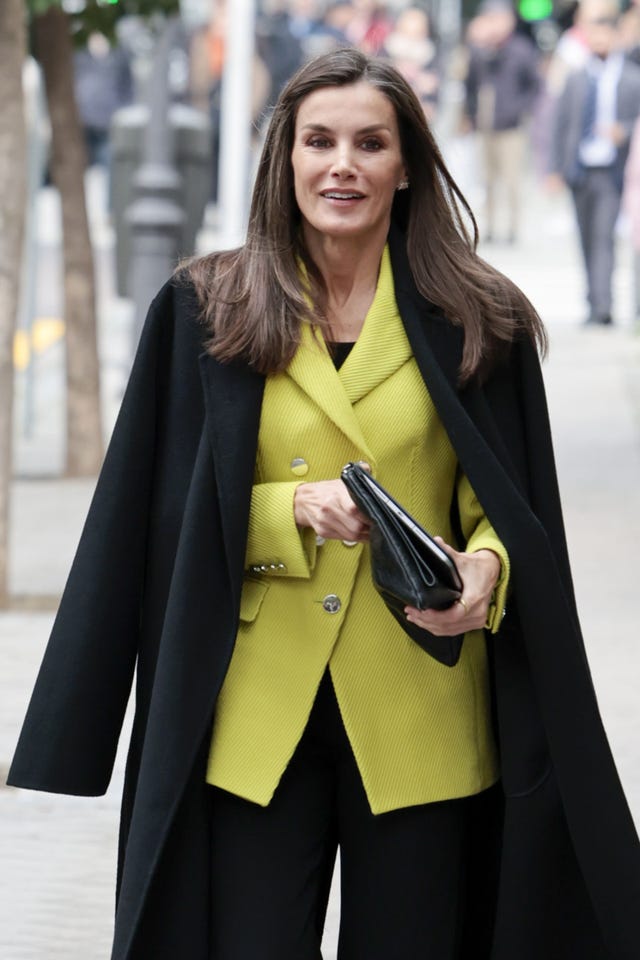 la reina con chaqueta color lima de boss para animar un total look en color negro en madrid