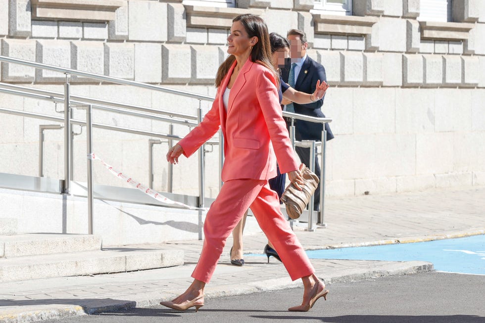 la reina letizia a su llegada a la aecid con un traje color coral en madrid