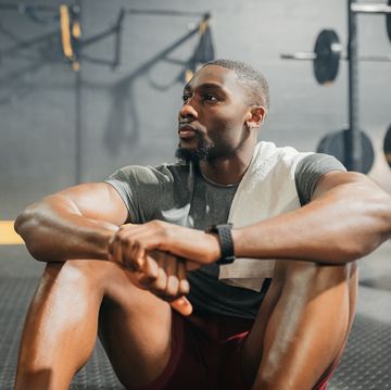 relax, thinking and black man in training gym resting his body after weightlifting workout muscular, healthy and strong fitness person on exercise break thoughtful while relaxing on floor