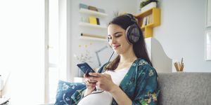 pregnancy quotes pregnant woman smiling whilst looking at phone