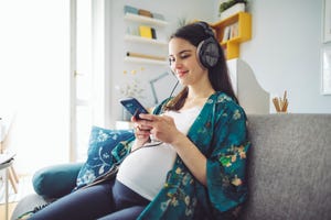 pregnancy quotes pregnant woman smiling whilst looking at phone