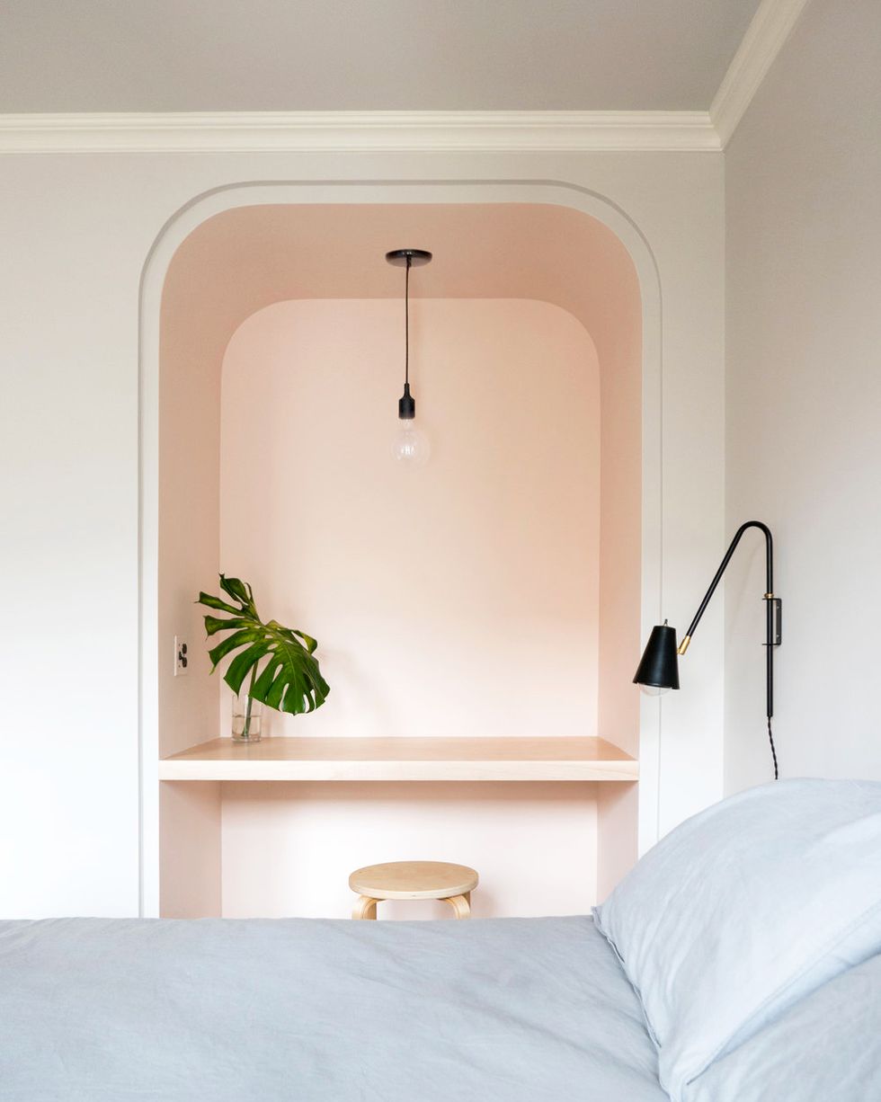 bedroom with small pink workspace