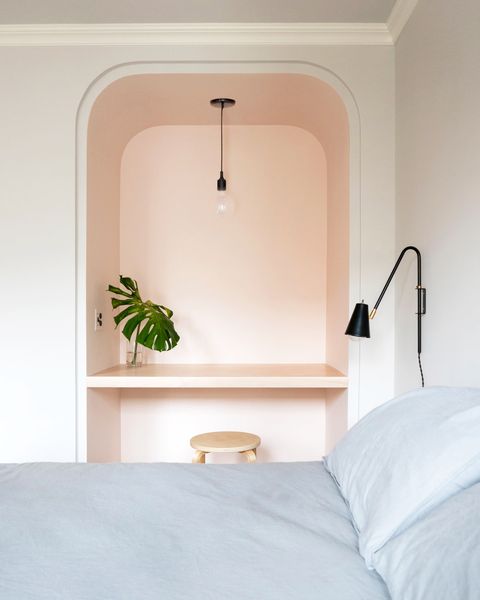 bedroom with small pink workspace
