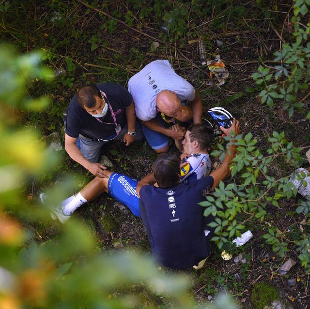 evenepoel lying in a ravine, surrounded by medics, after crashing into a stone wall at the 114th il lombardia 2020