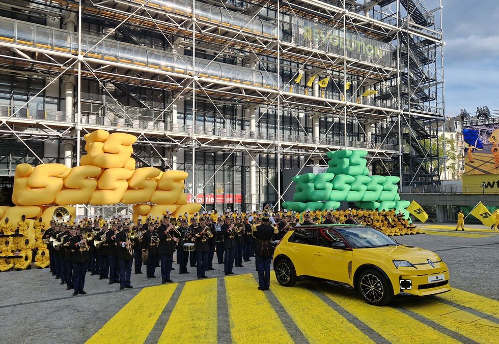 a yellow car parked in front of a large crowd of people