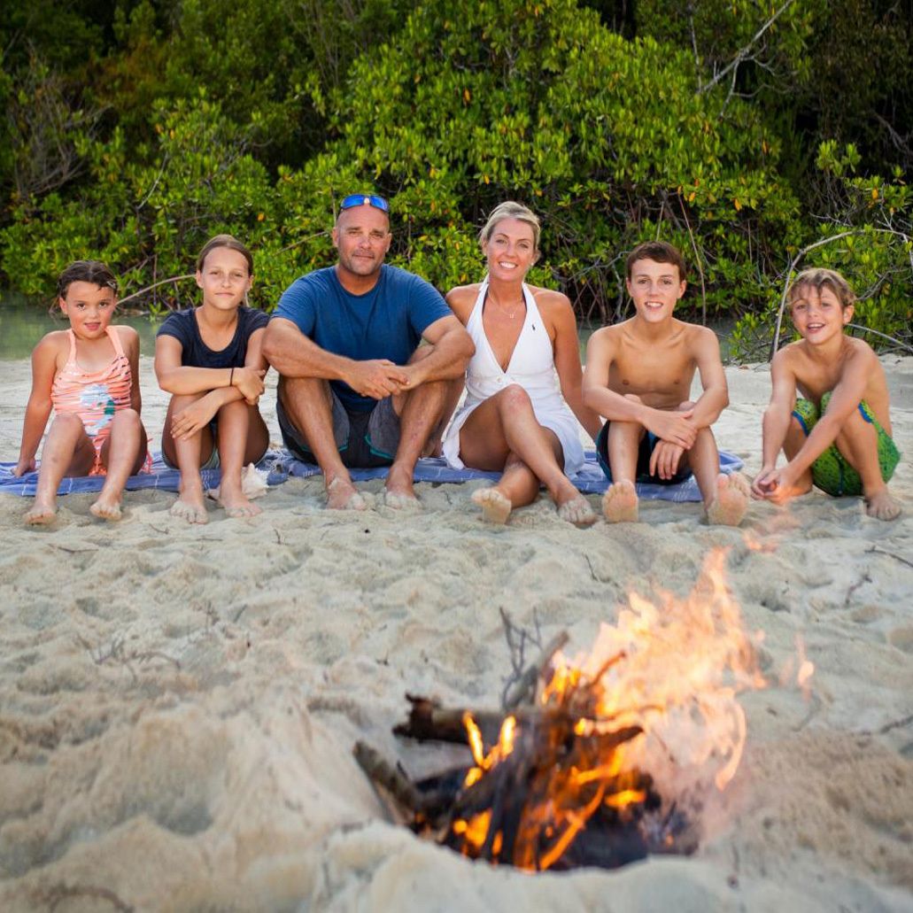 baeumler family of six on a beach in front of campfire