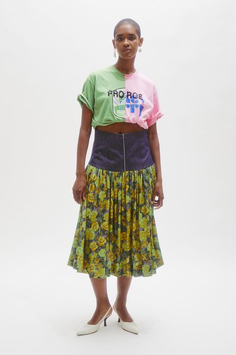 a black woman with short hair wears a shirt that reads pro roe and a floral skirt