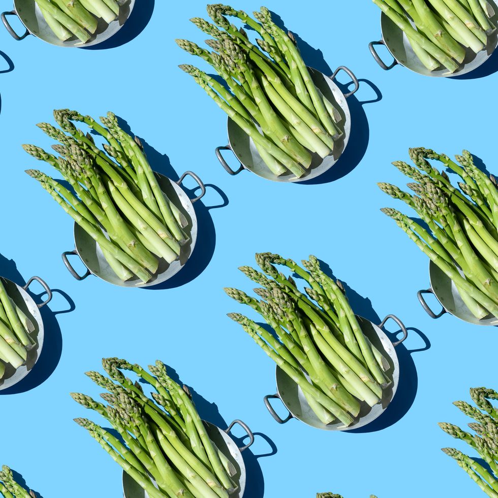 repeated asparagus in a pan on the blue background