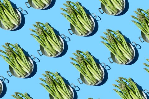 repeated asparagus in a pan on the blue background