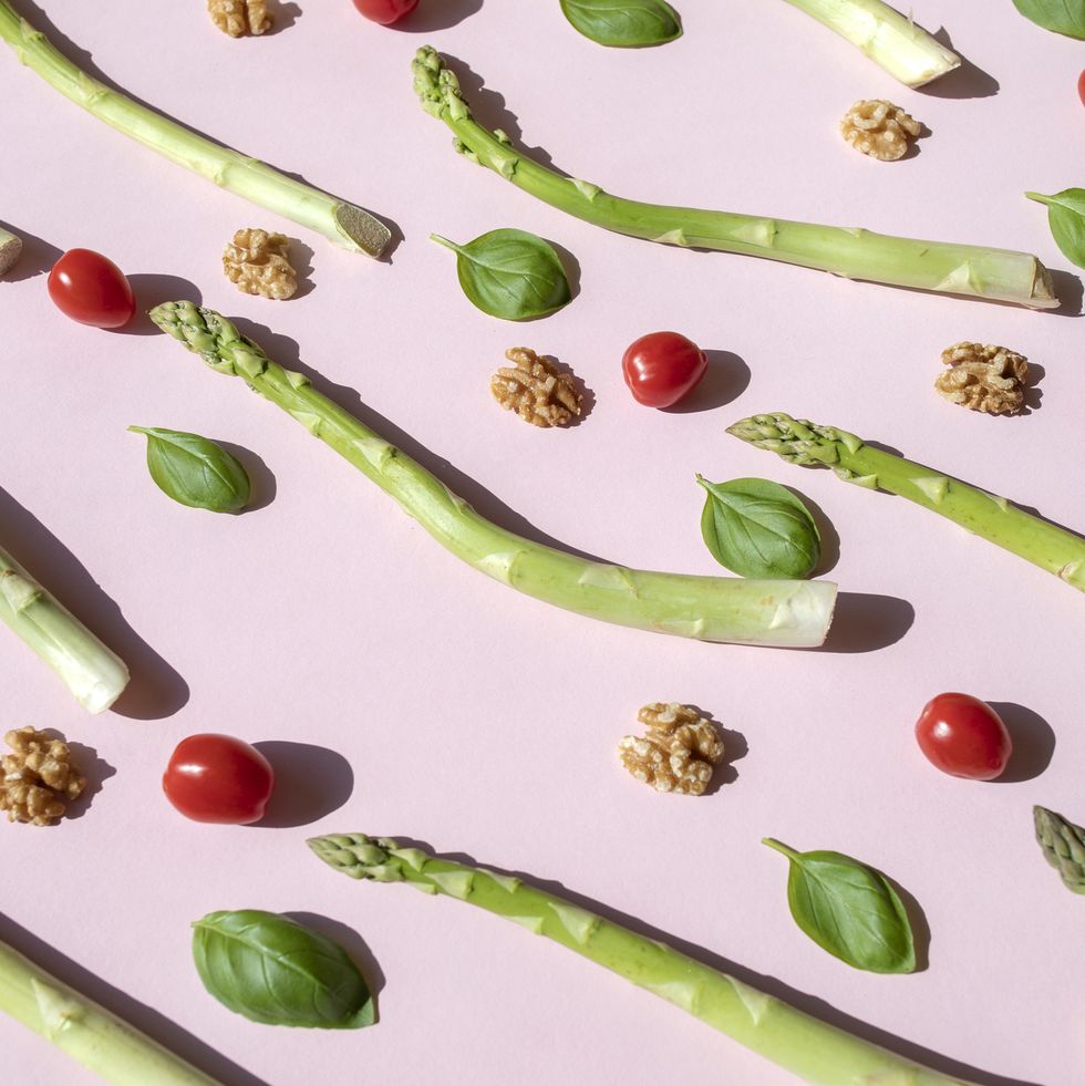 repeated asparagus, tomatoes and basil on the pink background